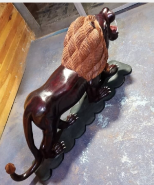 lion sculpté en bois sur son socle